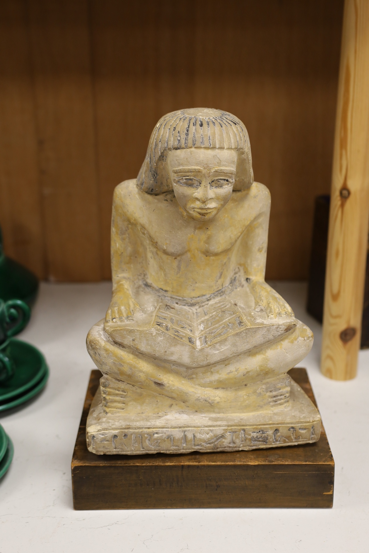 A carved stone Egyptian seated figure on wooden stand, 30cm high not including stand. Condition - fair to good